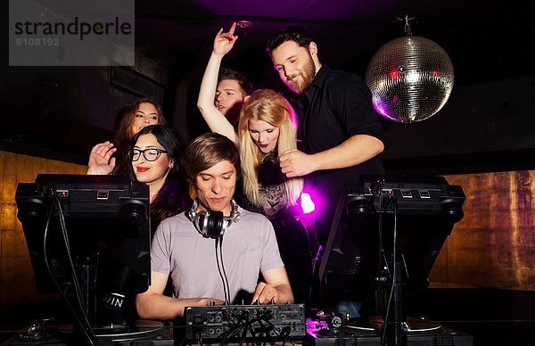 Gruppe von Freunden  die DJ in einem Nachtclub sehen.