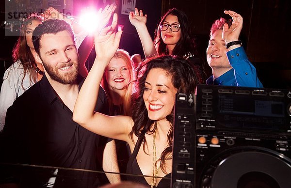 Gruppe junger Männer und Frauen  die in einem Nachtclub tanzen.