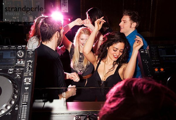 Gruppe von Freunden tanzen vor DJ im Nachtclub
