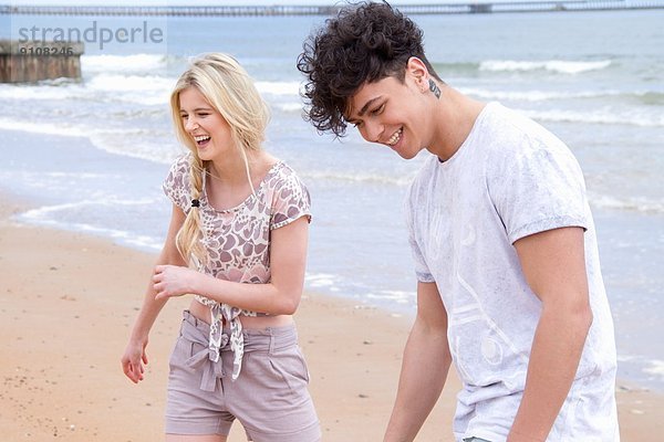 Glückliches junges Paar beim Strandspaziergang