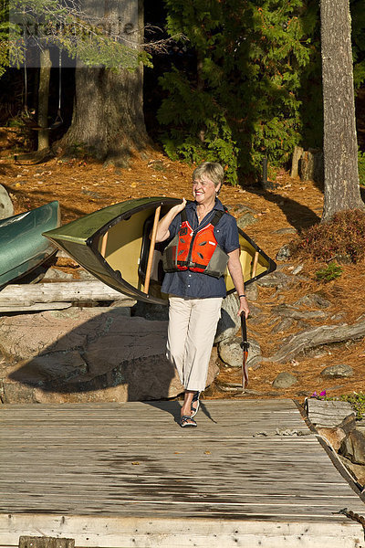 Frau  tragen  See  reifer Erwachsene  reife Erwachsene  Kanu  Algonquin Provincial Park  Kanada  Ontario