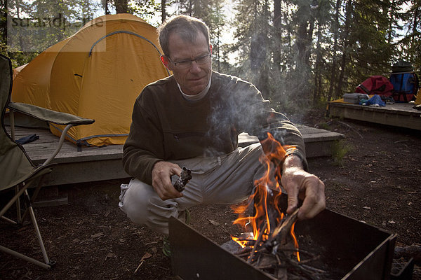 Mann  Campingplatz  reifer Erwachsene  reife Erwachsene  Feuer  Mittelpunkt  Start  Northwest Territories  Kanada