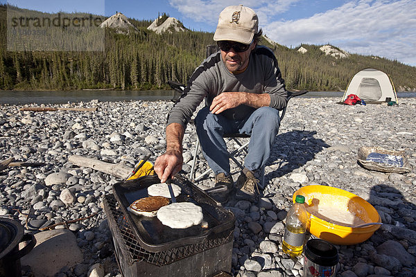 kochen  Mann  über  camping  Fluss  reifer Erwachsene  reife Erwachsene  Mittelpunkt  Pfannkuchen  Northwest Territories  Kanada