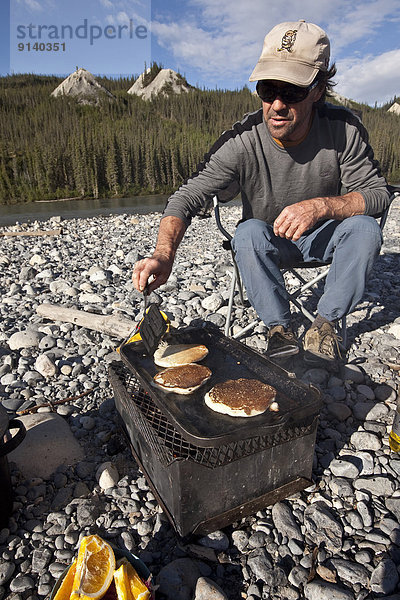 kochen  Mann  über  camping  Fluss  reifer Erwachsene  reife Erwachsene  Mittelpunkt  Pfannkuchen  Northwest Territories  Kanada