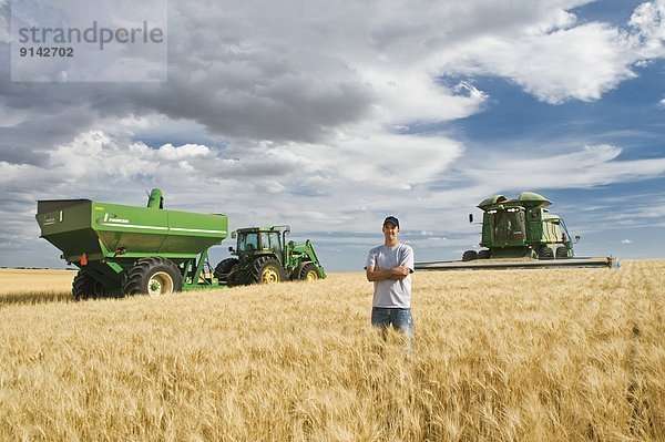 Getreide  ernten  Hintergrund  reifer Erwachsene  reife Erwachsene  Feld  Bauer  jung  Weizen  Saskatchewan  Mähdrescher  Kanada