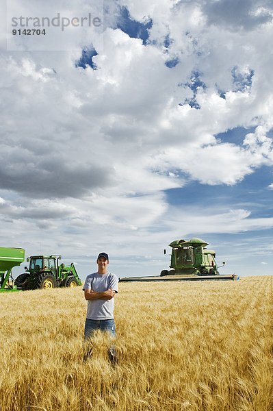 Getreide  ernten  Hintergrund  reifer Erwachsene  reife Erwachsene  Feld  Bauer  jung  Weizen  Mähdrescher  Kanada