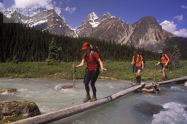 'Tonquin Valley; 3 women crossing Eremite Creek  Jasper National Park  Alberta  Canada'
