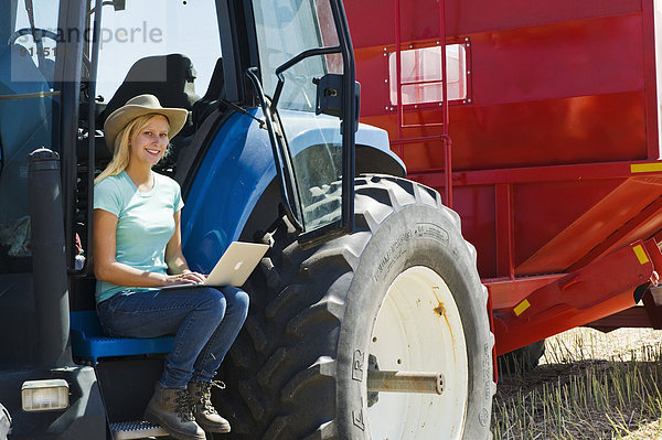 benutzen  Getreide  Computer  Notebook  Traktor  ernten  Bauernhof  Hof  Höfe  Terrasse  Mädchen  Kanada  Manitoba