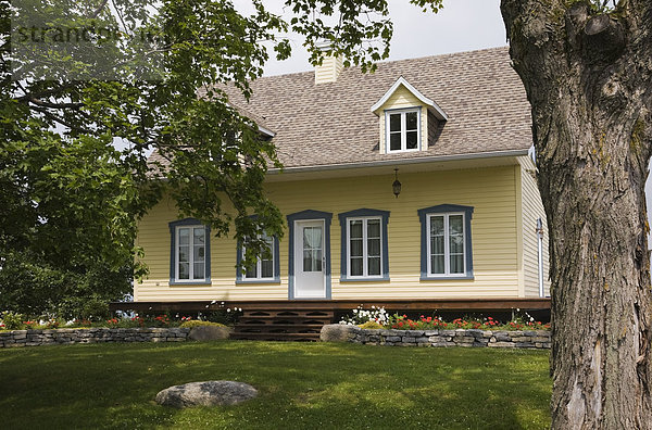 Lifestyle Wohnhaus Sommer gelb Garten frontal blau beschneiden Nachbarschaft Landschaftsarchitektur kanadisch Kanada alt Quebec