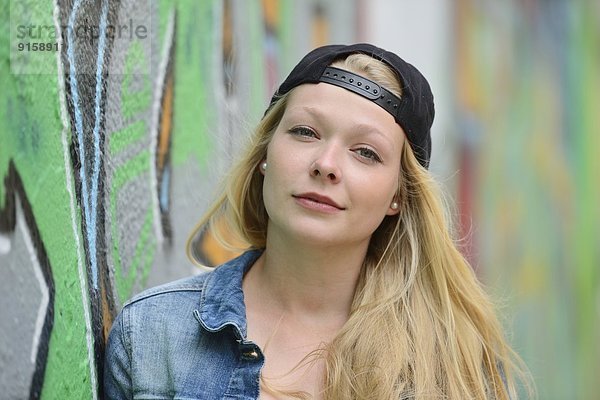 Junge Frau an einer Graffitiwand  Nürnberg  Bayern  Deutschland  Europa