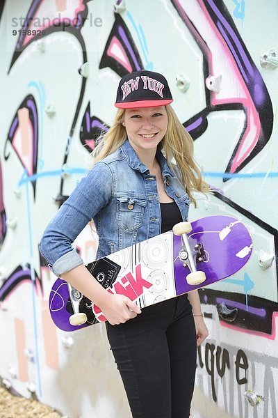 Junge Frau an einer Graffitiwand  Nürnberg  Bayern  Deutschland  Europa