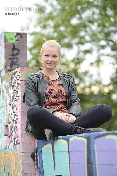 Junge Frau an einer Graffitiwand  Nürnberg  Bayern  Deutschland  Europa