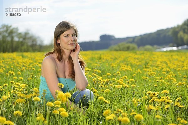 Junge Frau in einer Blumenwiese  Bayern  Deutschland  Europa