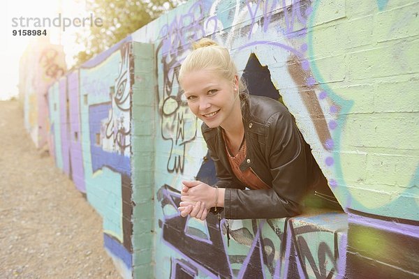 Junge Frau an einer Graffitiwand  Nürnberg  Bayern  Deutschland  Europa