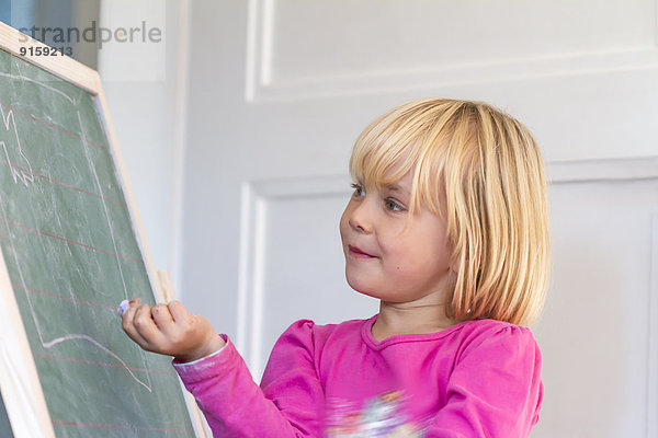 Mädchen spielt Schule an einer Tafel