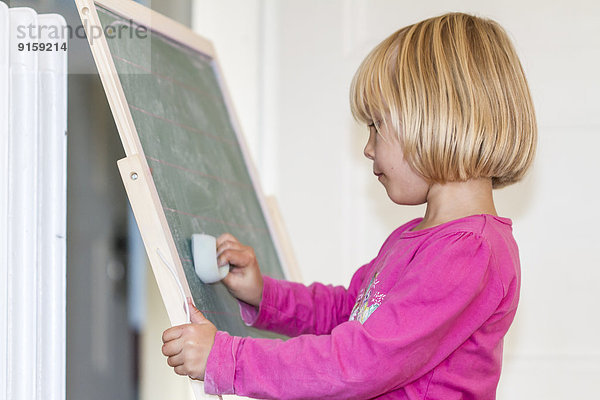 Mädchen spielt Schule an einer Tafel