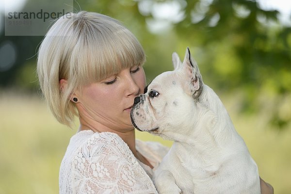 Frau mit einer sieben Monate alten Französischen Bulldogge