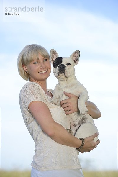 Frau mit einer sieben Monate alten Französischen Bulldogge