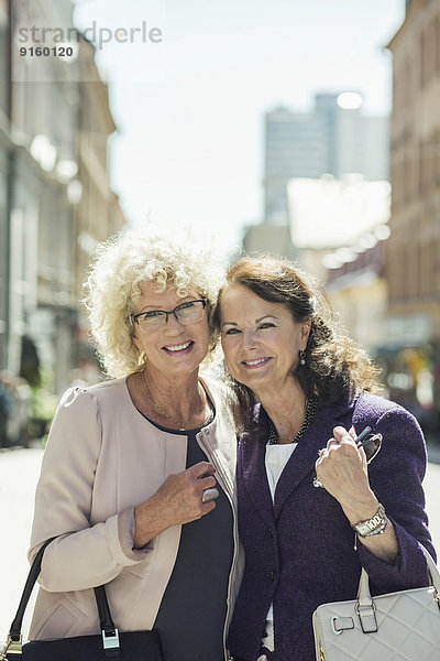 Portrait of happy senior women standing on street