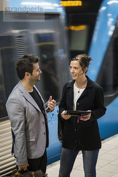 Geschäftsmann und Geschäftsfrau Kommunikation am U-Bahnhof