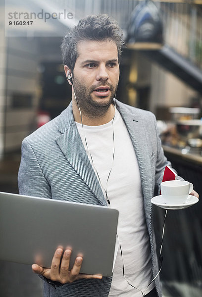 Mittlerer Erwachsener Mann mit Laptop und Kaffee im Cafe