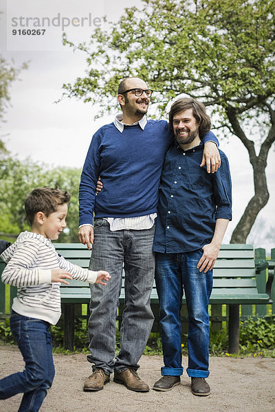 Zärtliches schwules Paar mit Sohn beim Spielen im Park