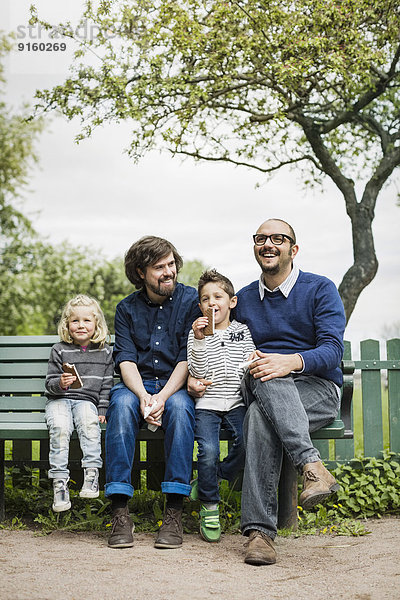 Glückliche männliche homosexuelle Familie  die ihre Freizeit im Park verbringt.