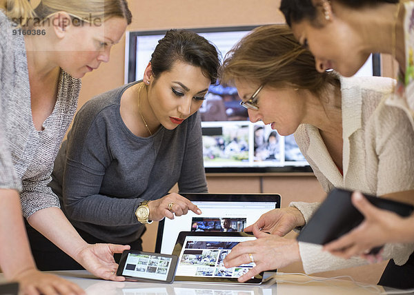 Fotoredakteurinnen diskutieren über digitales Tablett im Kreativbüro