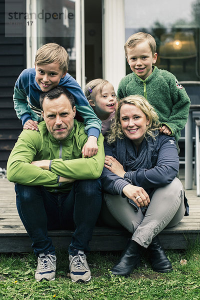 Porträt einer glücklichen Familie auf der Veranda