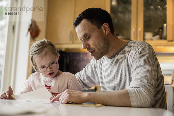 Vater hilft behinderter Tochter beim Lernen zu Hause
