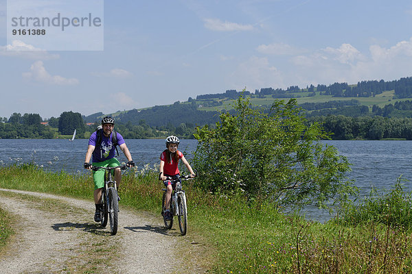 Vater und Kind auf Fahrradtour am Rottachspeicher  Rottachsee  Oberallgäu  Schwaben  Bayern  Deutschland