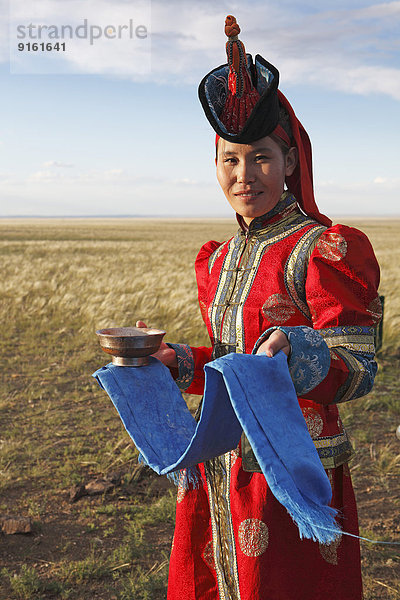 Frau in Tracht mit traditionellen Begrüßungsutensilien  blaues Tuch und Schale Milch  Wüste Gobi  Südwüste  Ömnö-Gobi-Aimag  Mongolei