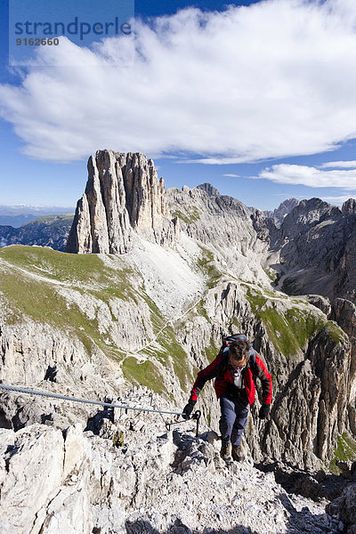 Bergsteiger beim Aufstieg auf die Rotwand in der Rosengartengruppe über den Rotwandklettersteig  unten der Vaiolonpass  hinten die Tscheinerspitzen  Dolomiten  Südtirol  Italien