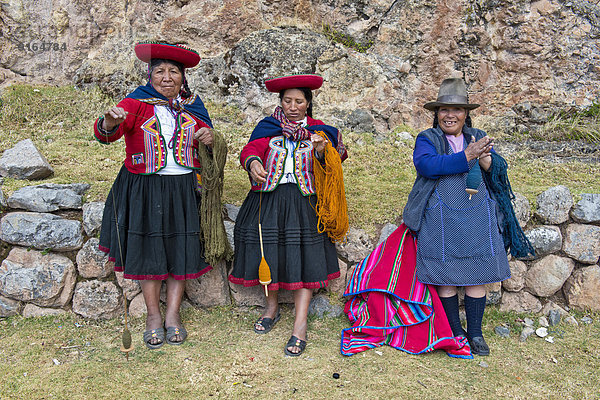 Drei ältere Frauen mit Hüten  Quechua-Indianer in traditioneller Kleidung spinnen mit Holzspindeln Wolle  Cinchero  Urubambatal  Peru