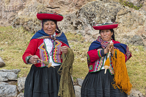 Zwei ältere Frauen mit Hüten  Quechua-Indianer in traditioneller Kleidung spinnen mit Holzspindeln Wolle  Cinchero  Urubambatal  Peru