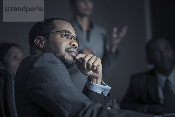 Business people watching projection in meeting