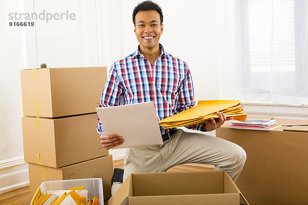 Mixed race man packing cardboard boxes