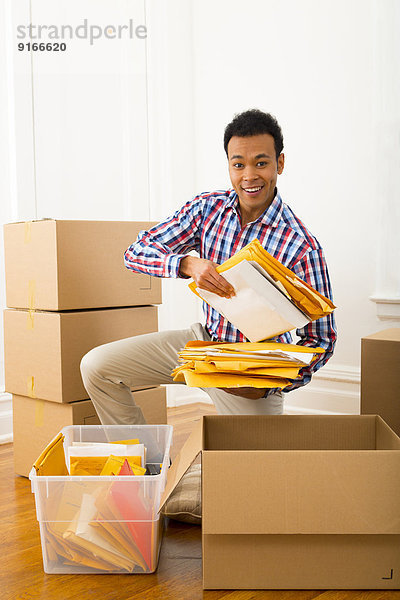 Mixed race man packing cardboard boxes