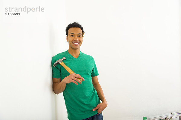 Mixed race man holding hammer