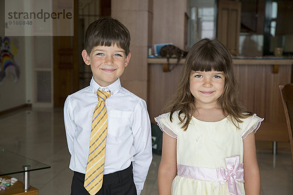 Caucasian children smiling in formal wear