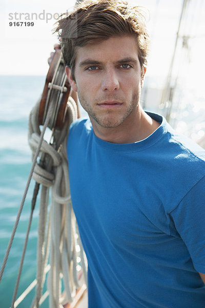 Caucasian man standing on sailboat