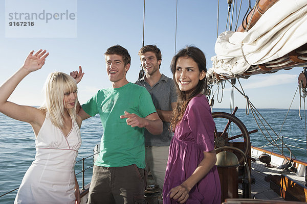 Caucasian friends dancing on sailboat