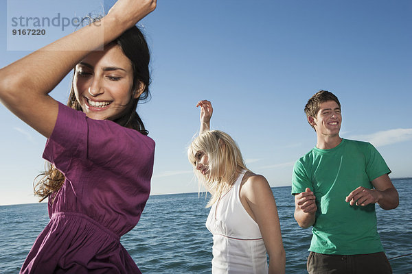 Caucasian friends dancing on sailboat