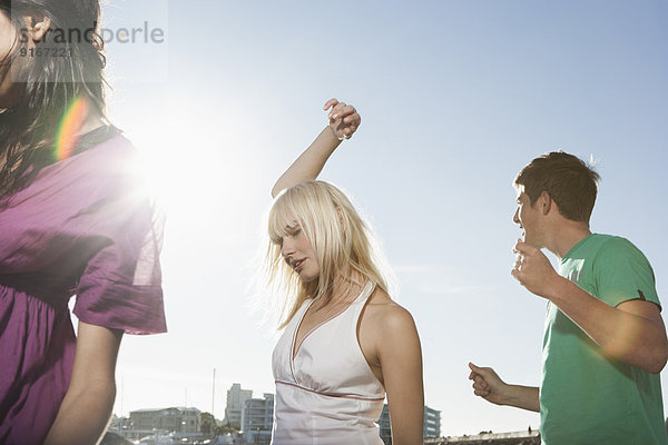 Caucasian friends dancing outdoors