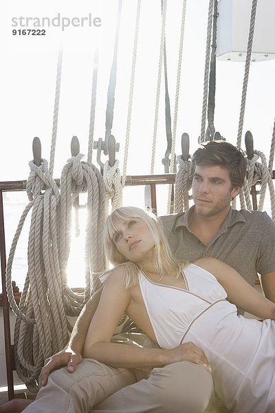 Caucasian couple relaxing on sailboat