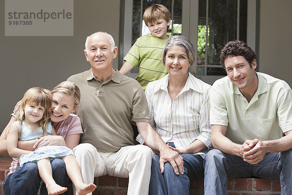 Caucasian multi-generation family smiling on porch