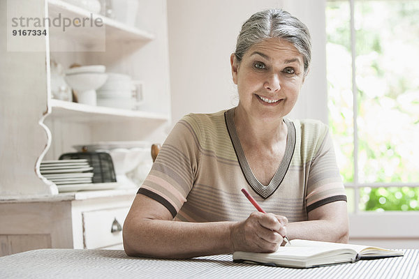 Caucasian woman writing in journal