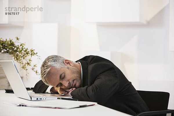 Businessman sleeping at desk in office