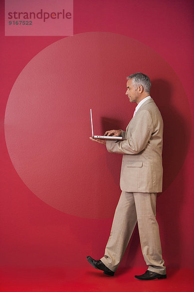 Businessman walking with laptop