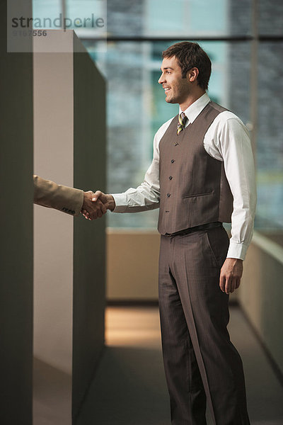 Businessmen shaking hands in office